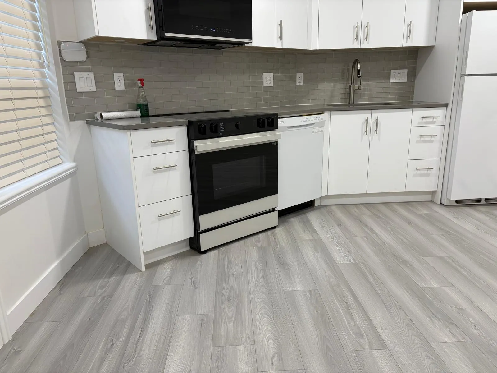 Vinyl plank flooring - kitchen (after) - Grey basement suite